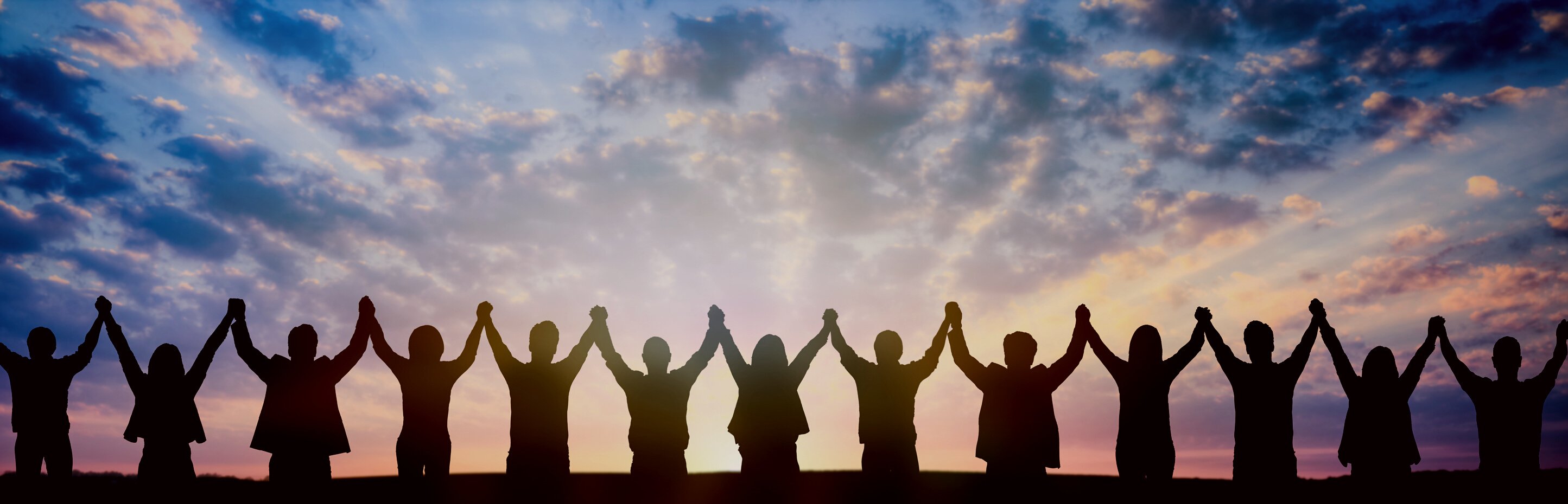 Silhouette of Business Team Holding Hands at Sunset